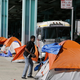 A man stands outside his tent on Division Street in San Francisco in 2016. San Francisco voters will decide in November 2018 whether to tax large businesses to pay for homeless and housing services in a city struggling with income inequality.